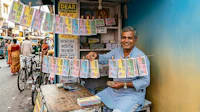 a man selling money on a street in varanasi, india