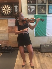 a woman playing the violin in a bar