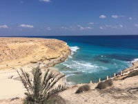 a view of a beach with sand and blue water