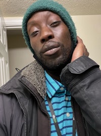 a man wearing a green beanie and a striped shirt