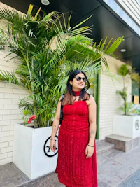 a woman in a red dress standing in front of a building