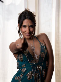 a woman in a blue dress pointing to the camera