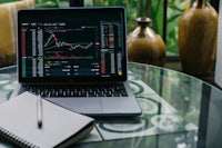 a laptop on a table with stock charts on it