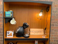 a wooden shelf with a coffee maker and mugs