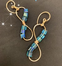 a pair of earrings with blue glass beads on them