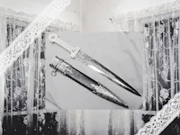 a black and white photo of a knife in front of a window