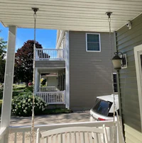 the porch of a house with a swing