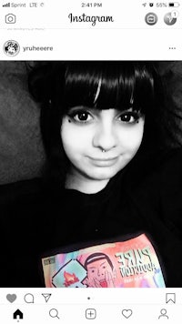 a black and white photo of a girl holding a t - shirt