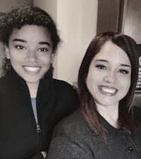 two women posing for a photo in a kitchen