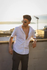 a man in a white shirt leaning against a wall