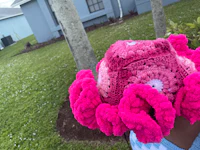 a child wearing a crocheted pink octopus hat