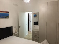 a bedroom with a white bed and a painting on the wall