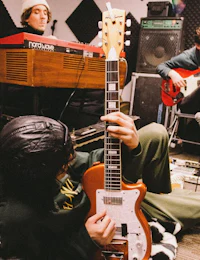 a group of people playing guitar in a recording studio