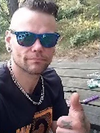 a man in sunglasses giving a thumbs up at a picnic table
