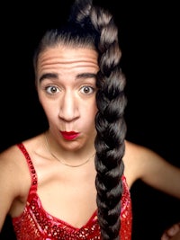a woman wearing a red dress with a braided hair