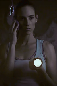 a woman in a tank top holding a flashlight