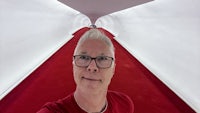 a man in glasses is taking a selfie in a tunnel