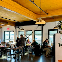 a group of people are sitting at tables in a restaurant