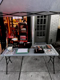 a booth with a table and chairs on a sidewalk