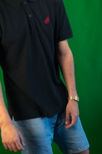 a man wearing a black polo shirt and shorts