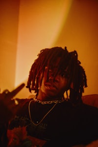 a man with dreadlocks sitting on a couch