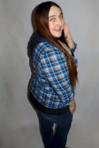 a woman wearing a blue plaid hoodie and jeans