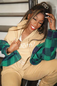 a woman wearing a tan jacket and green pants