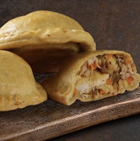 three chicken pies on a wooden cutting board
