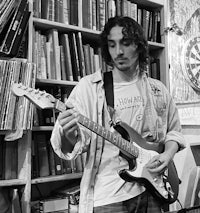 a man playing an electric guitar in a library