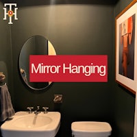 a bathroom with a mirror hanging on the wall