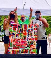 a group of people holding up a painting