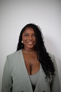 a young black woman in a grey blazer