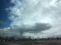 a cloudy sky with mountains in the background