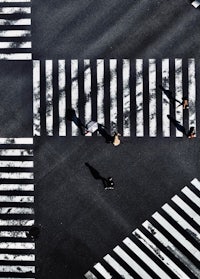an aerial view of people crossing a street