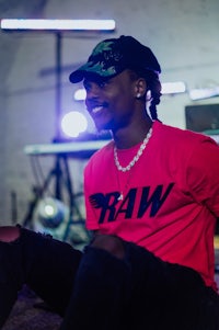 a man in a red t - shirt sitting on the floor