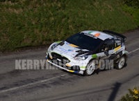 a ford fiesta rally car driving down a road