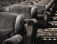 a row of black velvet chairs in a movie theater