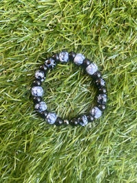 a black and white beaded bracelet on grass
