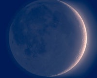 the moon is shown in a blue sky