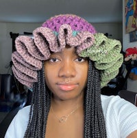 a woman wearing a crocheted ruffled hat