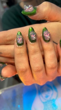 a woman's hands with green nail polish on them