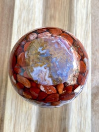 a red and brown stone ball on a wooden table