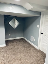 a room with gray carpet and a mirror