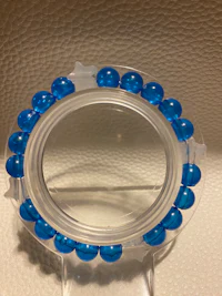 a blue glass bead ring on a white surface