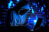 a man in a hoodie is working on a laptop