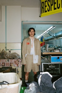 a man standing in a room full of clothes