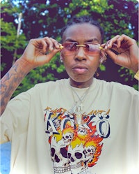 a man wearing sunglasses and a skull t - shirt