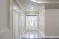 a hallway in a home with hardwood floors and a door