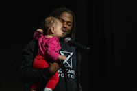 a man holding a baby in front of a microphone