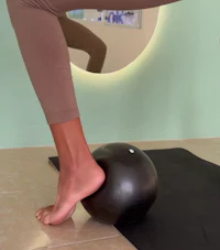 a woman is standing on a yoga ball